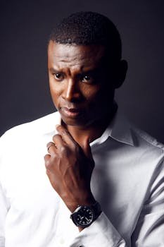 Portrait of a thoughtful man in a crisp white shirt with a serious expression.